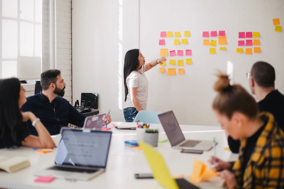 A colleague presenting at a whiteboard during a team session